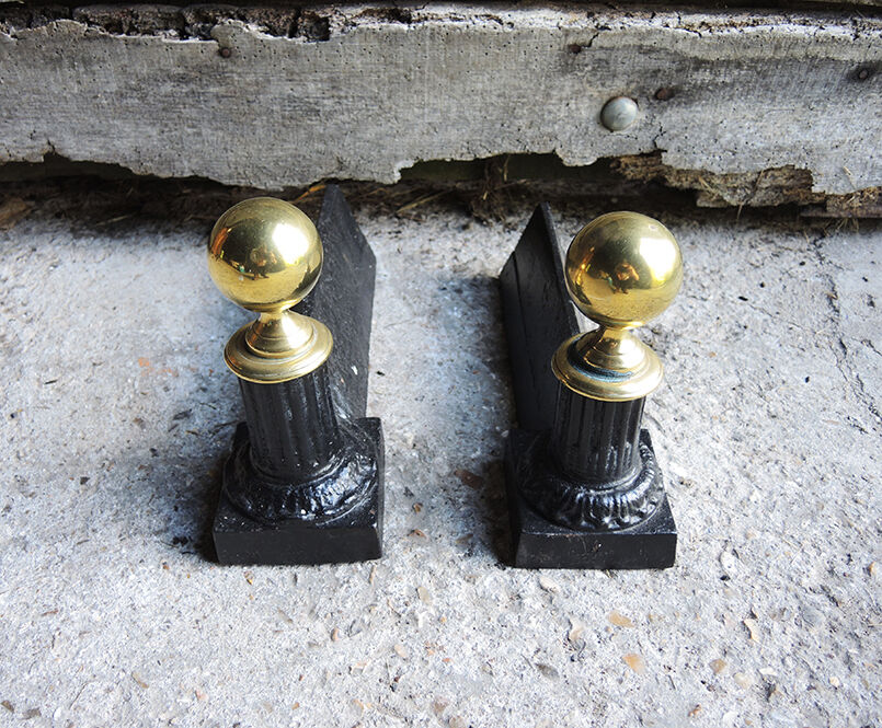 Old cast iron and brass andirons in neoclassical style