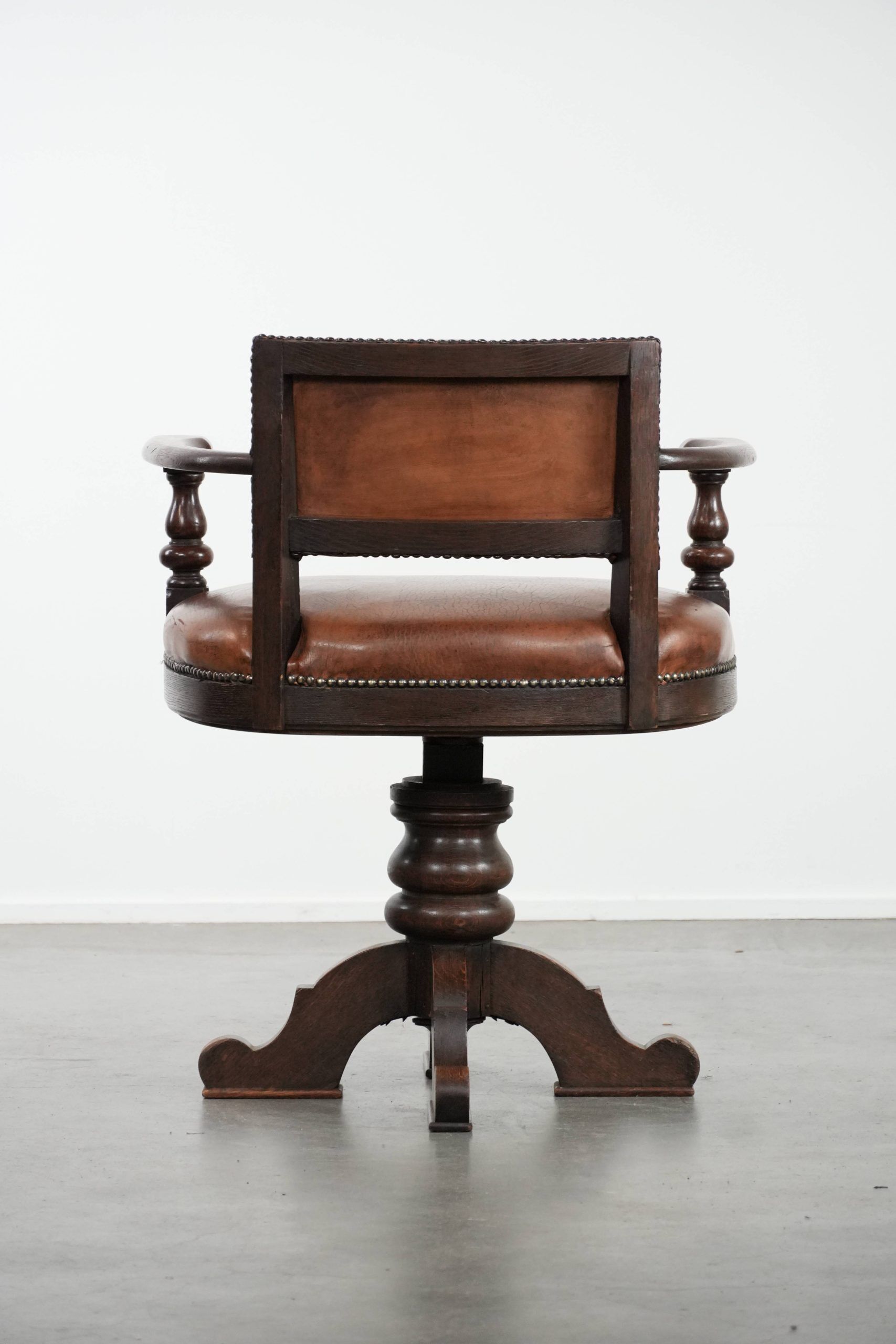 Elegant antique sheepskin leather desk chair with a heavy wooden frame
