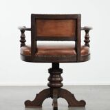 Elegant antique sheepskin leather desk chair with a heavy wooden frame