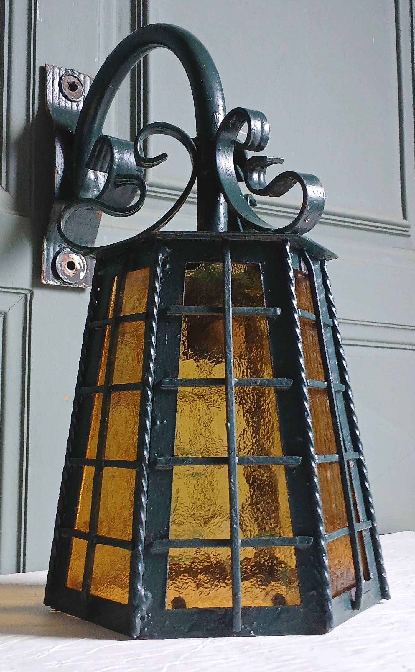 Wrought iron wall lantern & amber cathedral glass