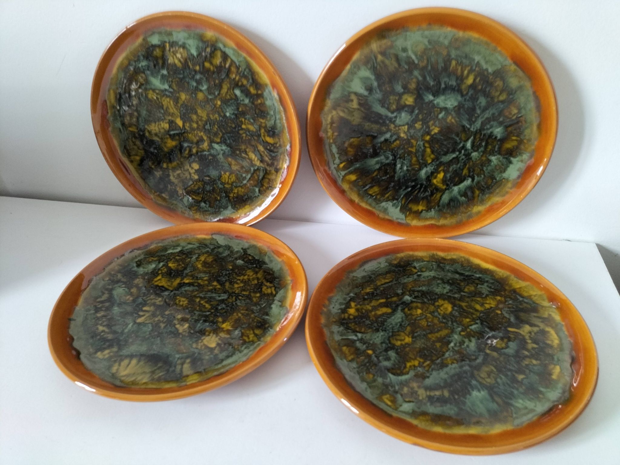 Set of 4 flamed enamel plates in green and amber from the 60s-70s.