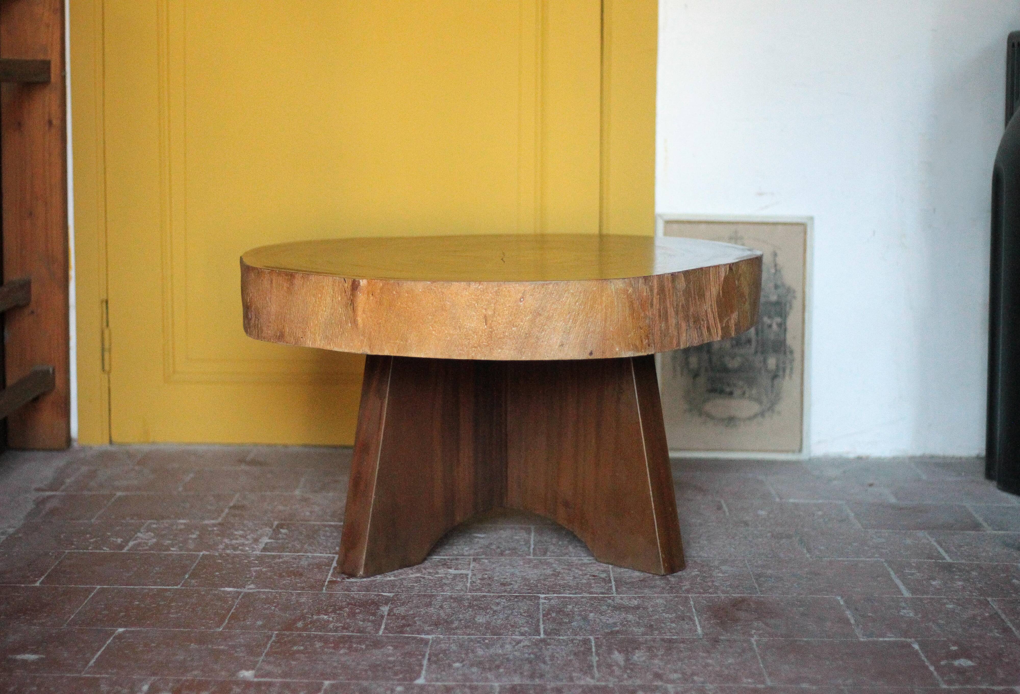 Brutalist wooden coffee table, cruciform leg with a tree trunk top.