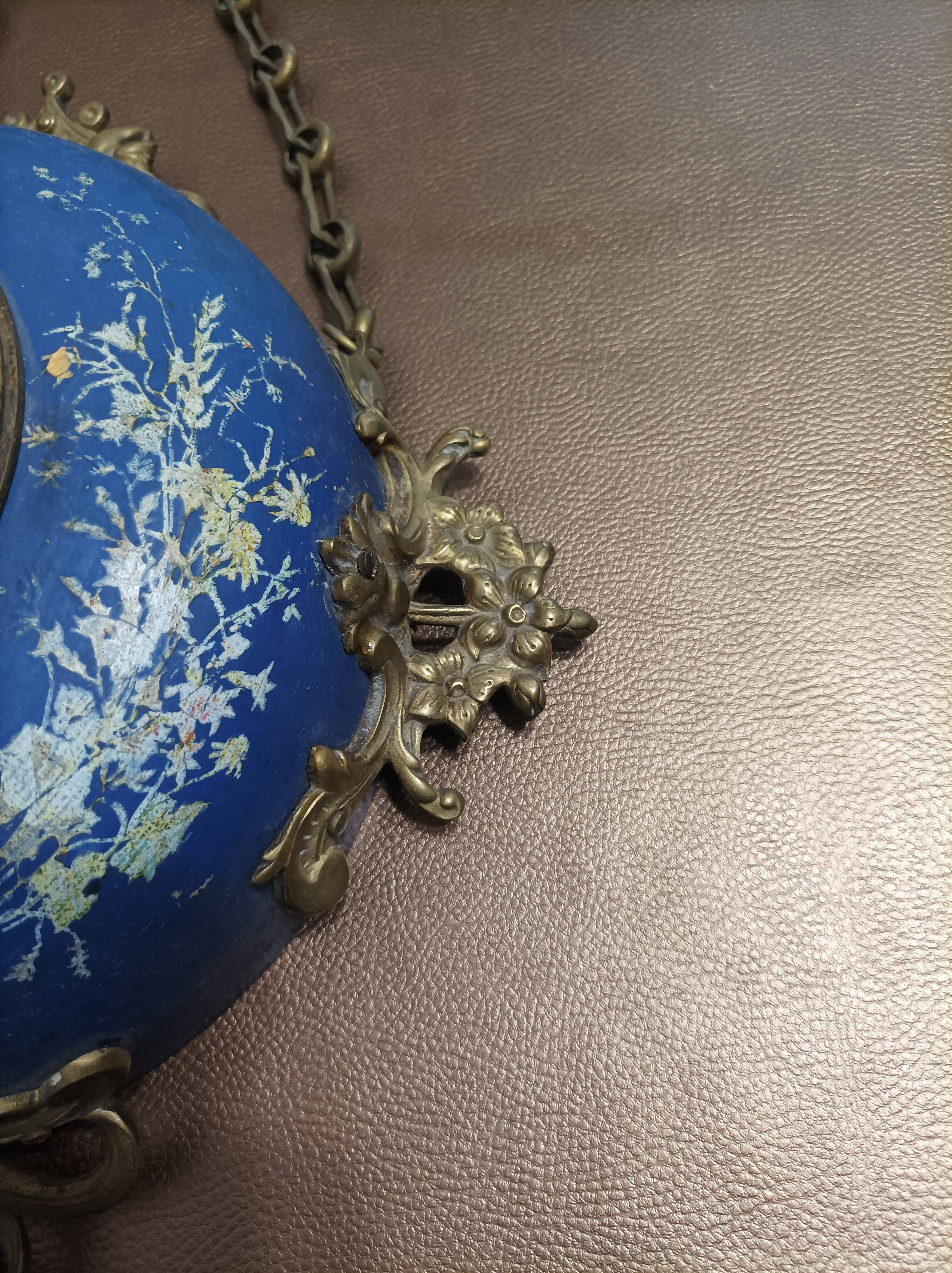 Wall clock in glazed earthenware decoration and brass chain empire style