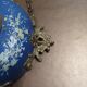 Wall clock in glazed earthenware decoration and brass chain empire style