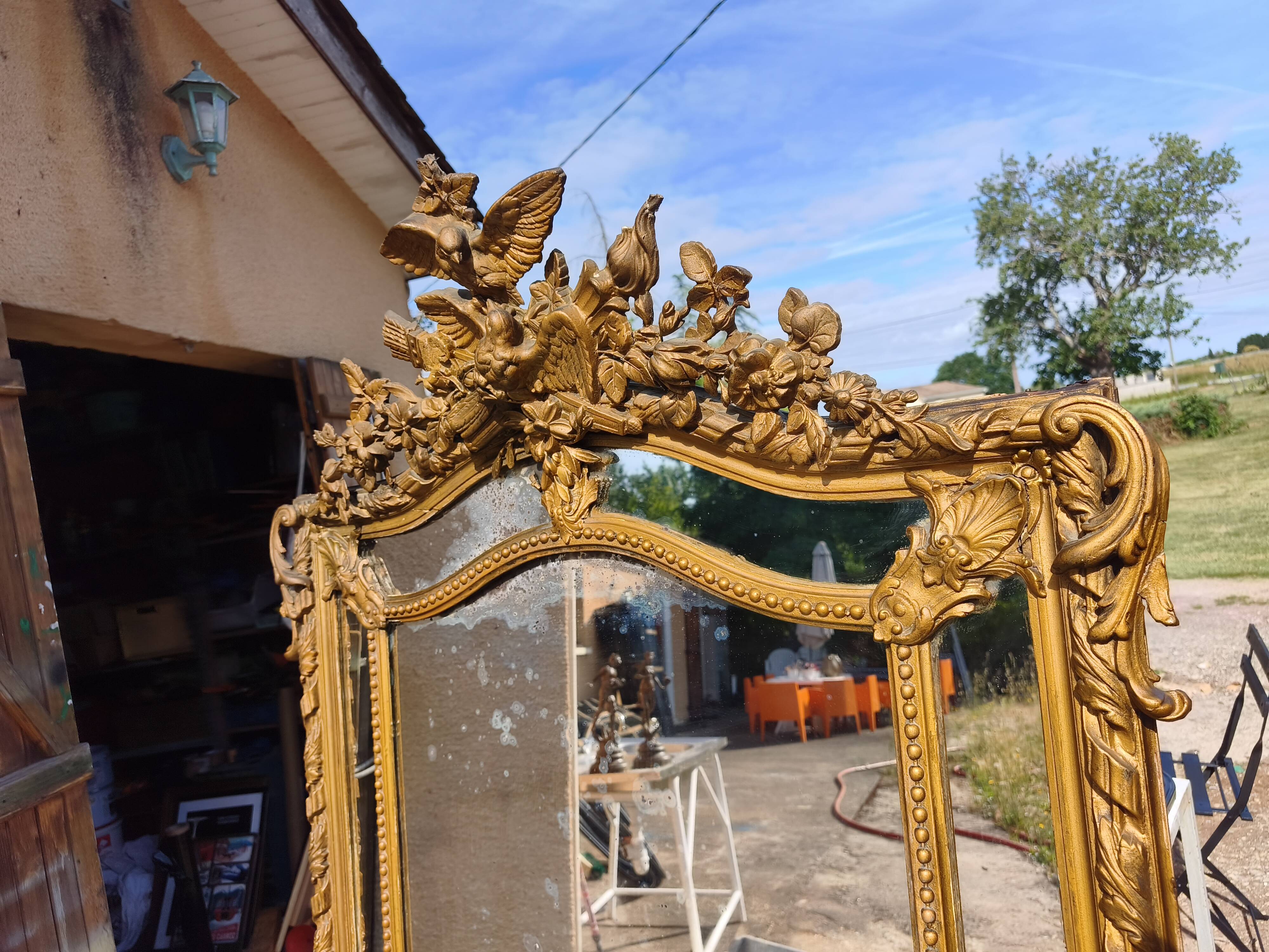 Large closed mirror, 19th century, wood and gilded stucco.