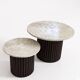 Round nesting coffee table in travertine and dark fluted wood.