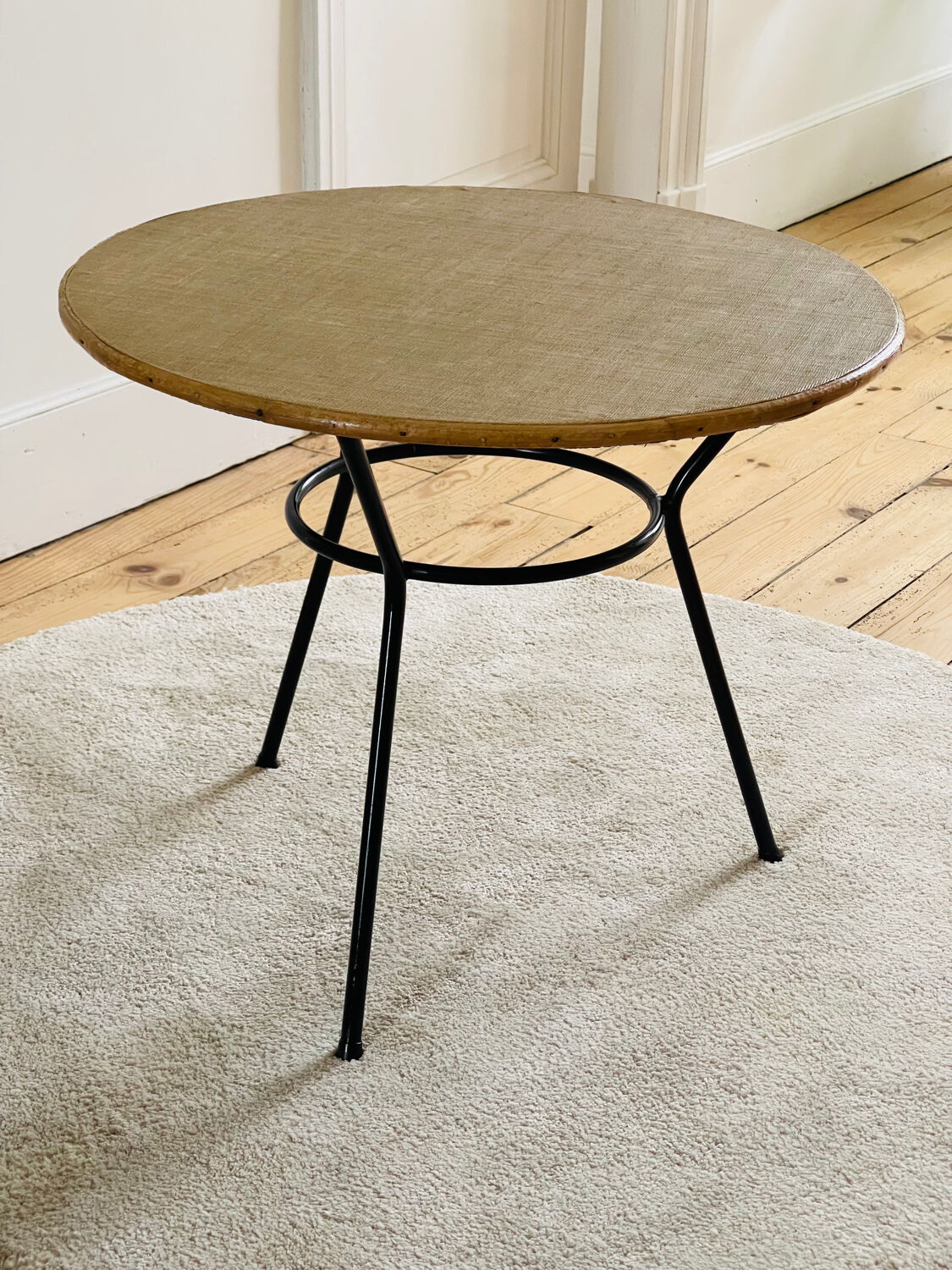 Tripod coffee table with a straw covering.