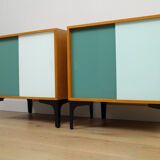 A pair of vintage mid-century bedside tables with glass sliding doors