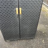 Contemporary wardrobe in black faux leather with diamond pattern and gold handles.