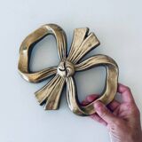 Bow-shaped brass trivet