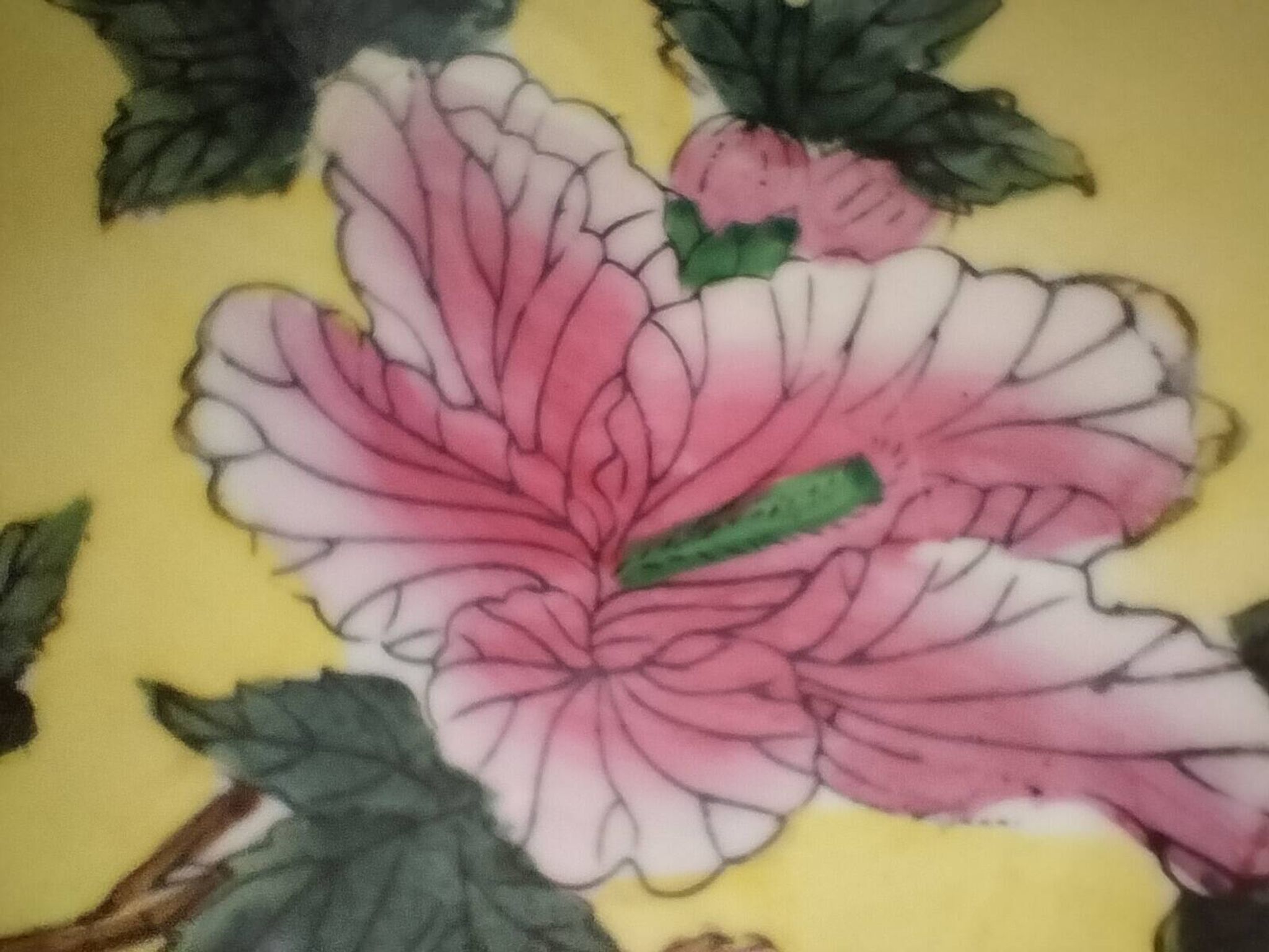 A pair of vintage Chinese decorative plates with floral designs on a yellow background.