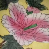 Pair of vintage Chinese decorative plates with floral decoration on a yellow background