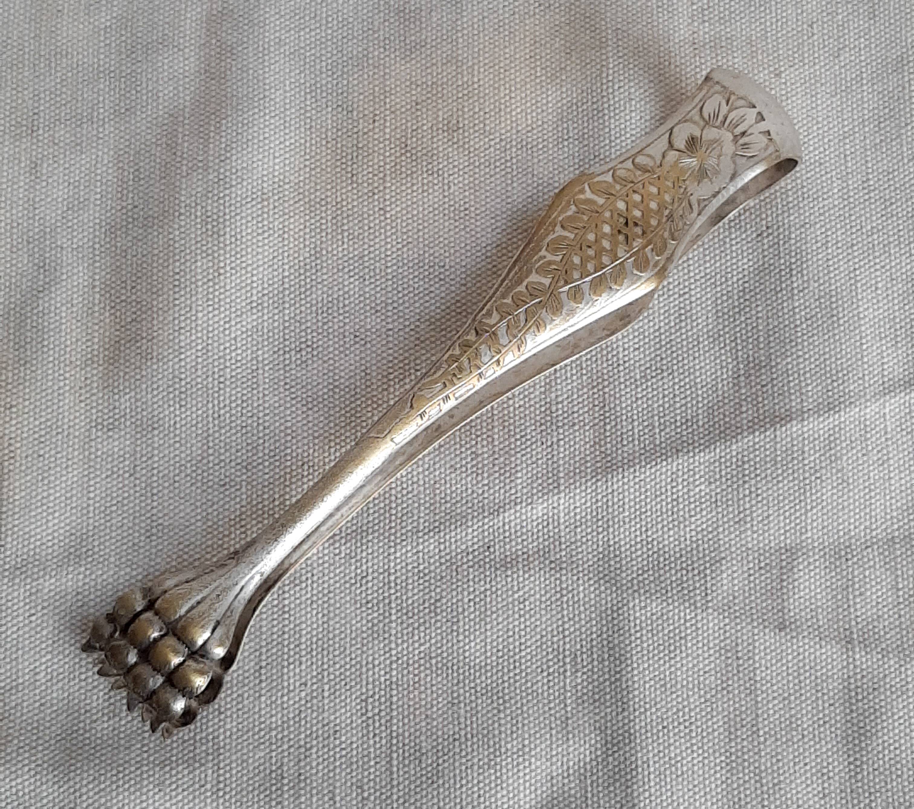 Antique silver-plated sugar tongs with lion's paws.