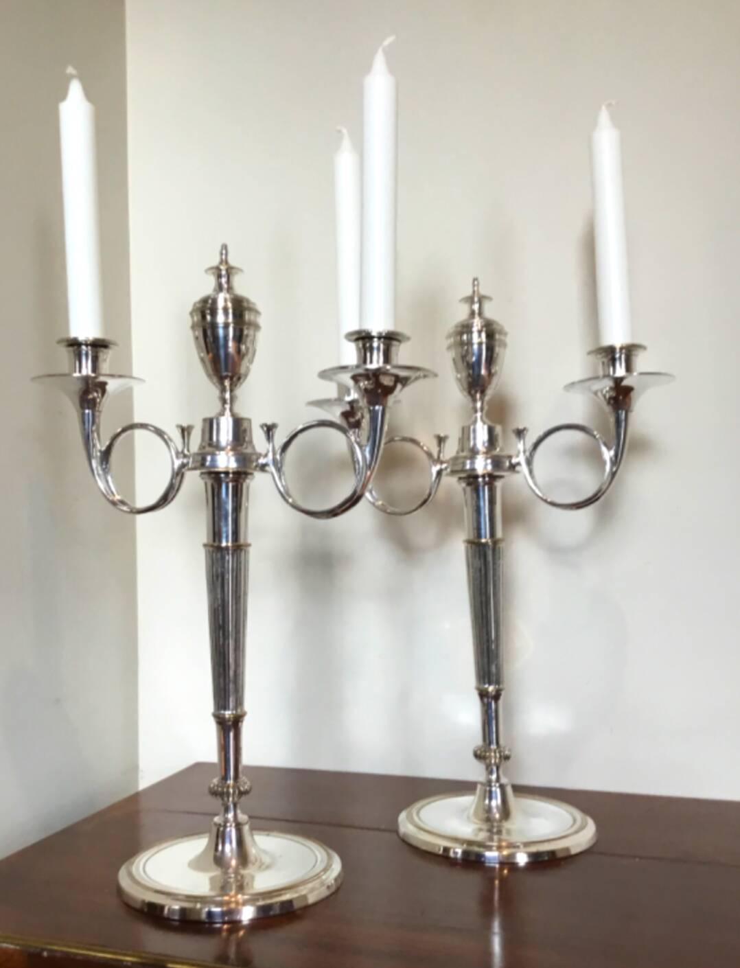 Pair of silver-plated metal candelabra decorated with hunting horns
