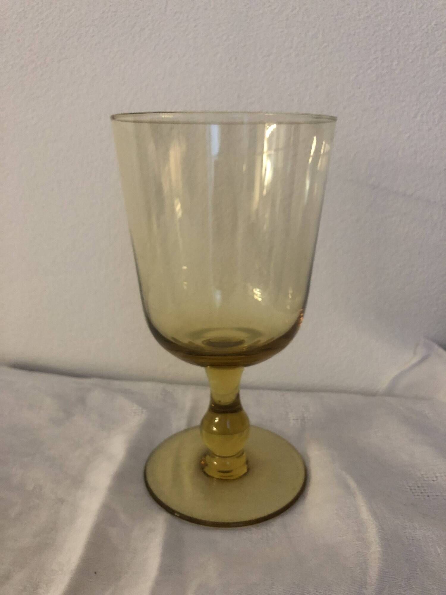 Yellow chalice vase, yellow glass vase on a pedestal.