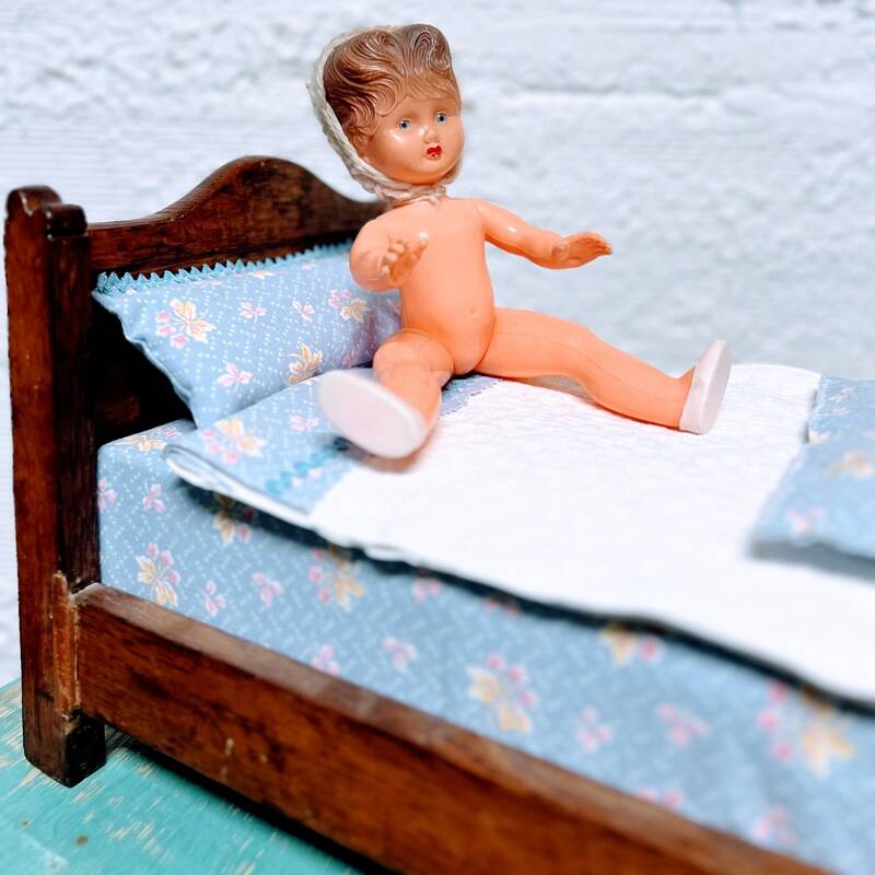 Old doll's bed in varnished wood