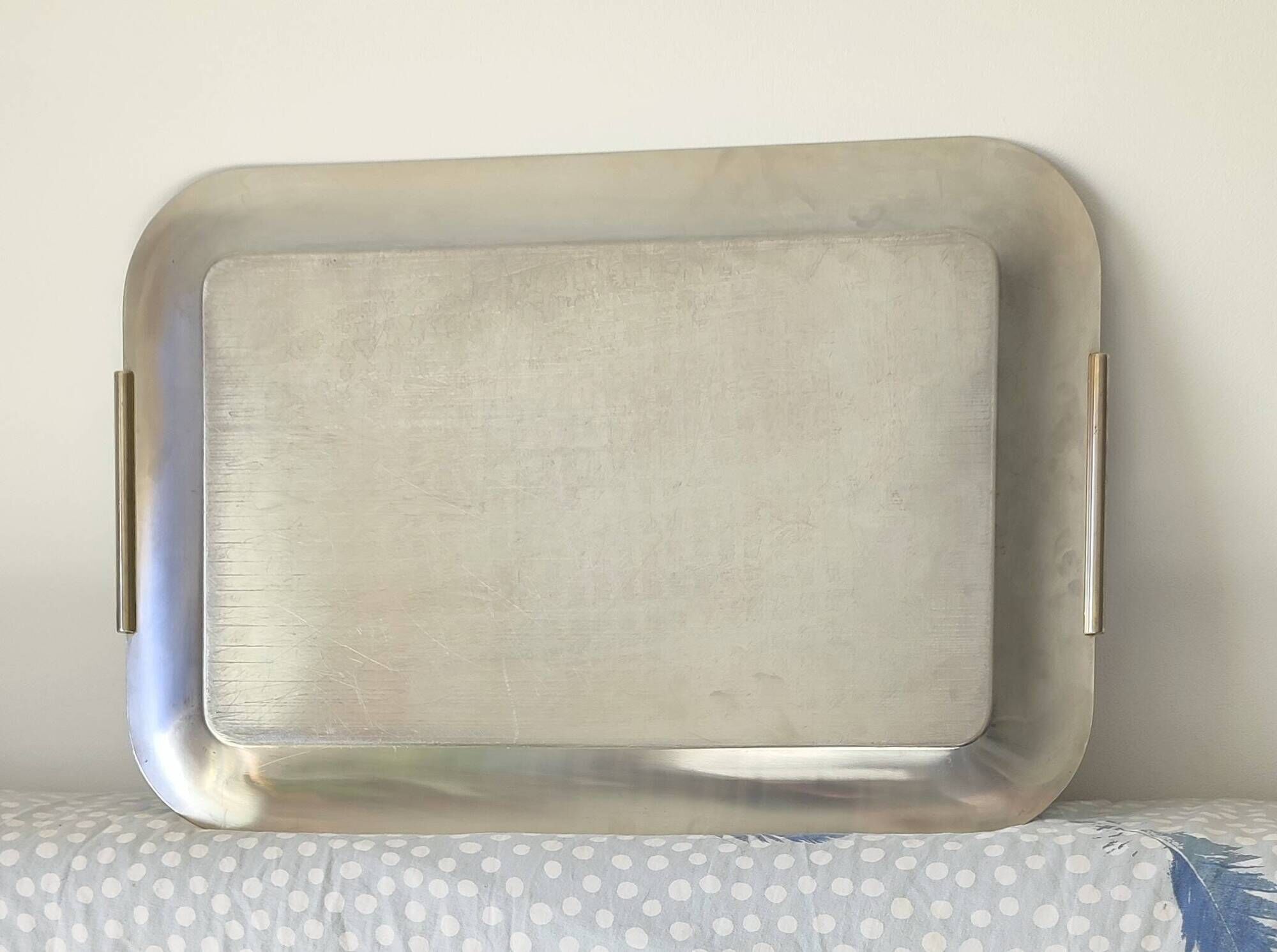 Vintage stainless steel serving platter with marine decor and golden handles.
