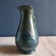 Vintage ceramic pitcher vase in glazed green and blue.