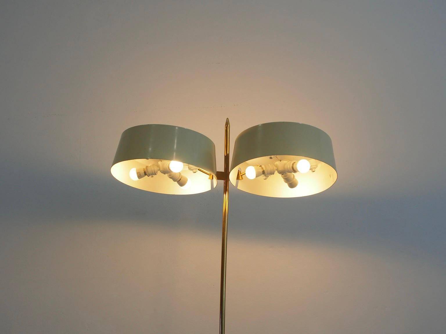Brass and lacquered metal floor lamp with a wooden magazine shelf.