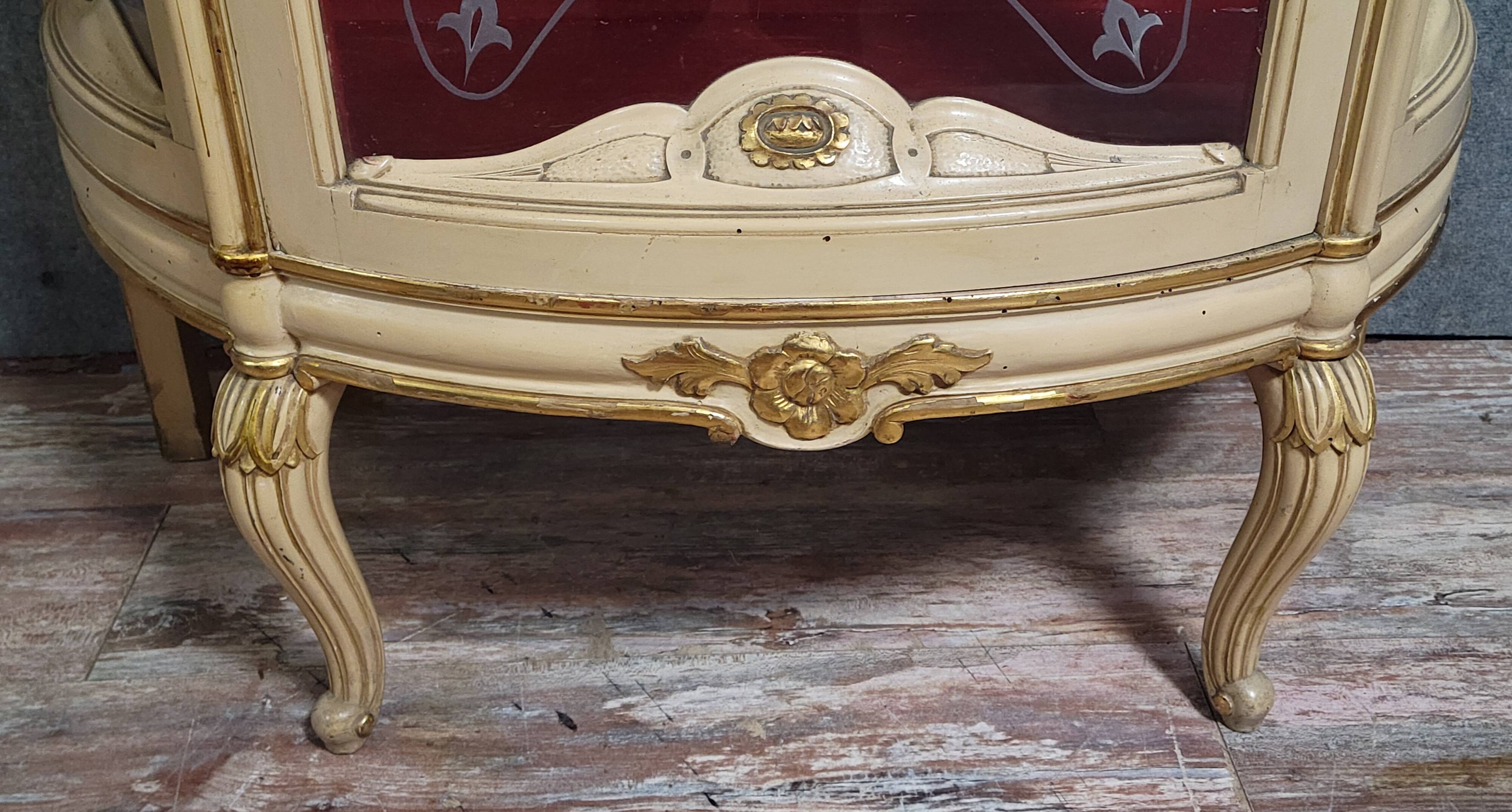 Curved display cabinet in Louis XV style, in cream lacquered wood enhanced with gilding.