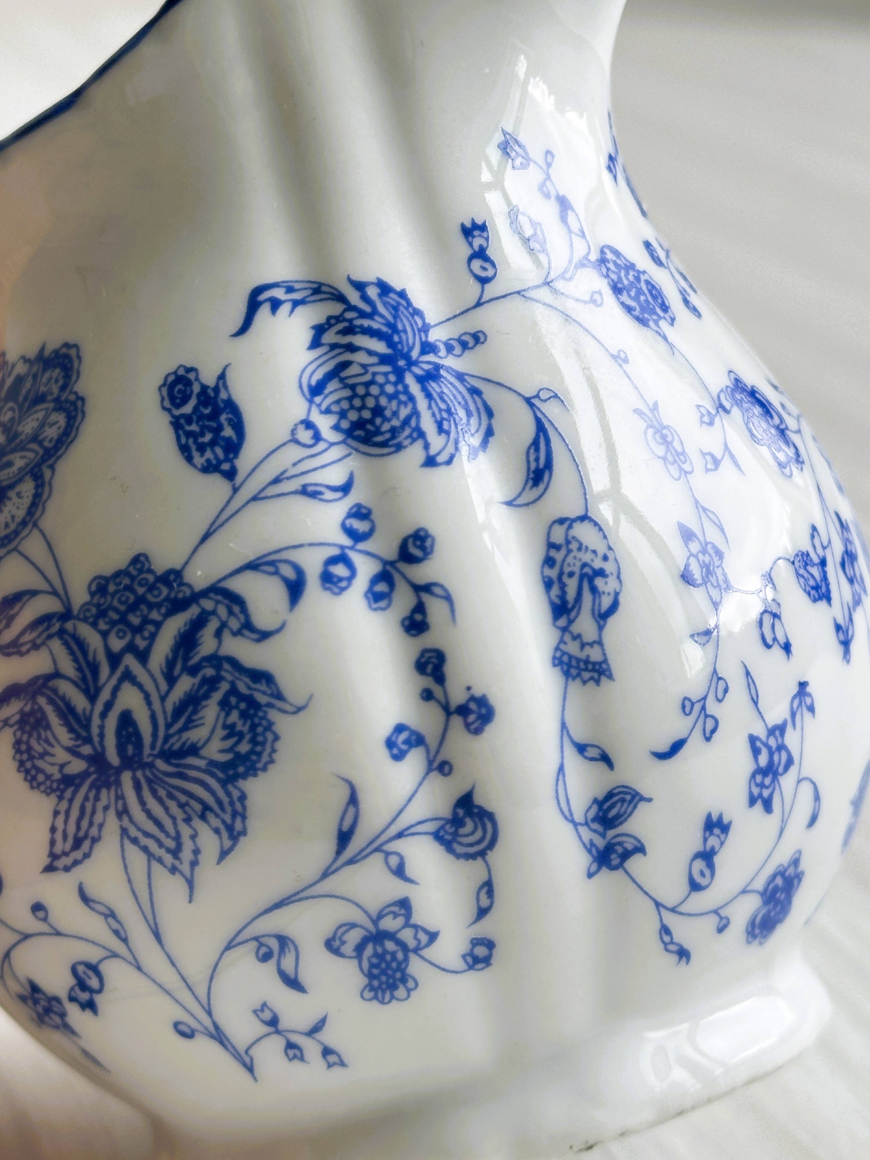 White porcelain milk jug with blue floral designs.