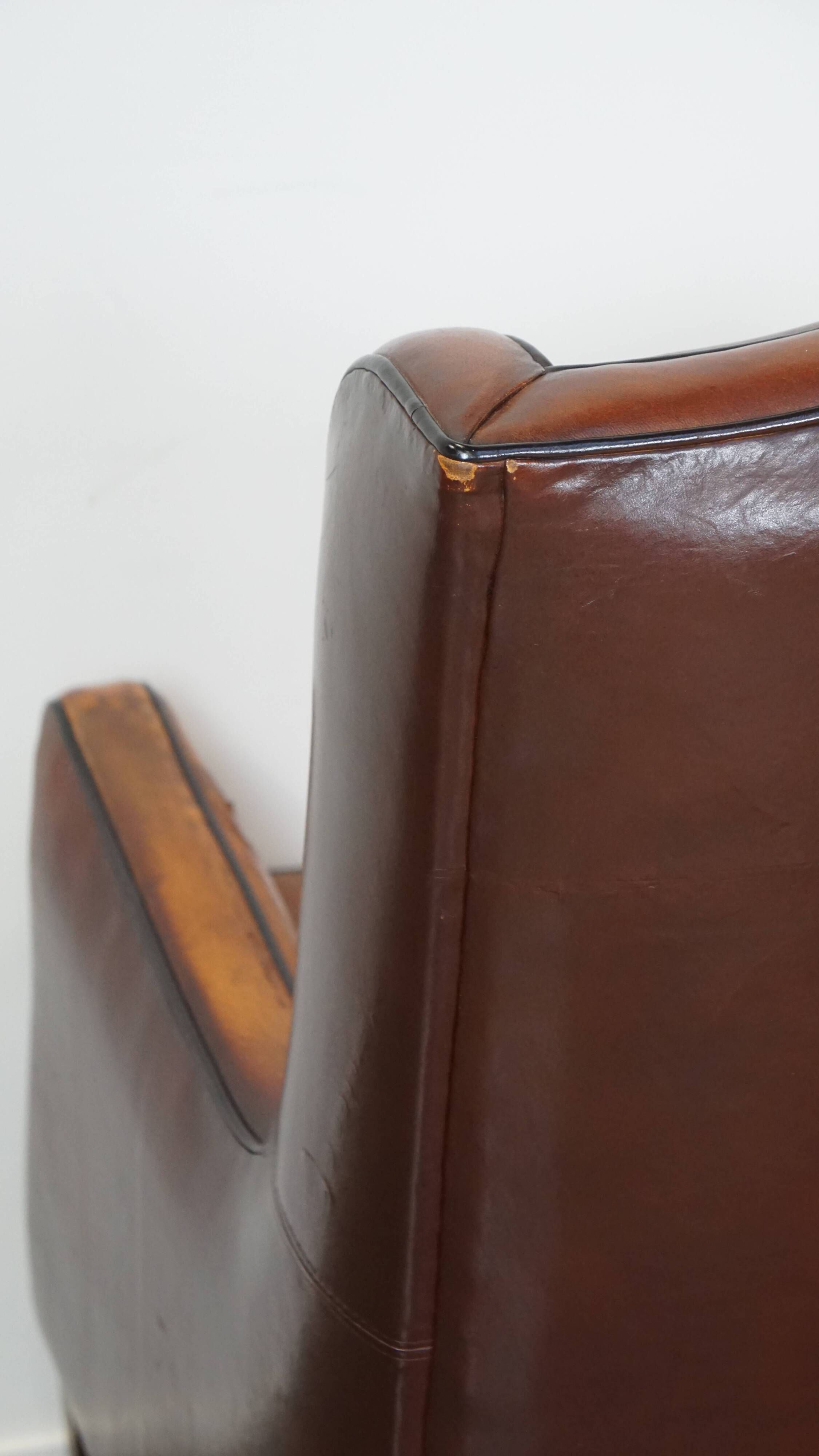 Vintage sheepskin leather armchair finished with black piping