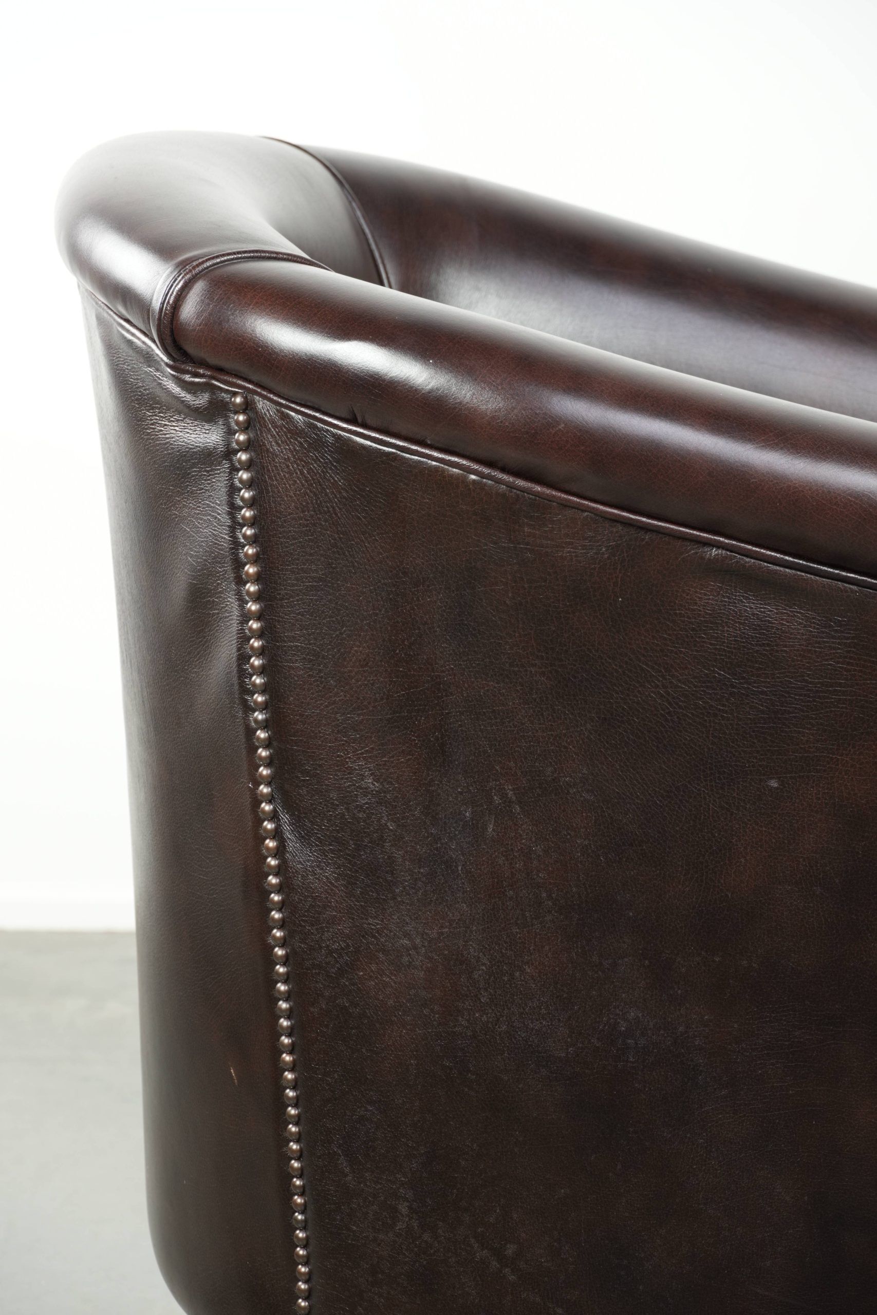 Dark cow leather club armchair with a stylish design in English style