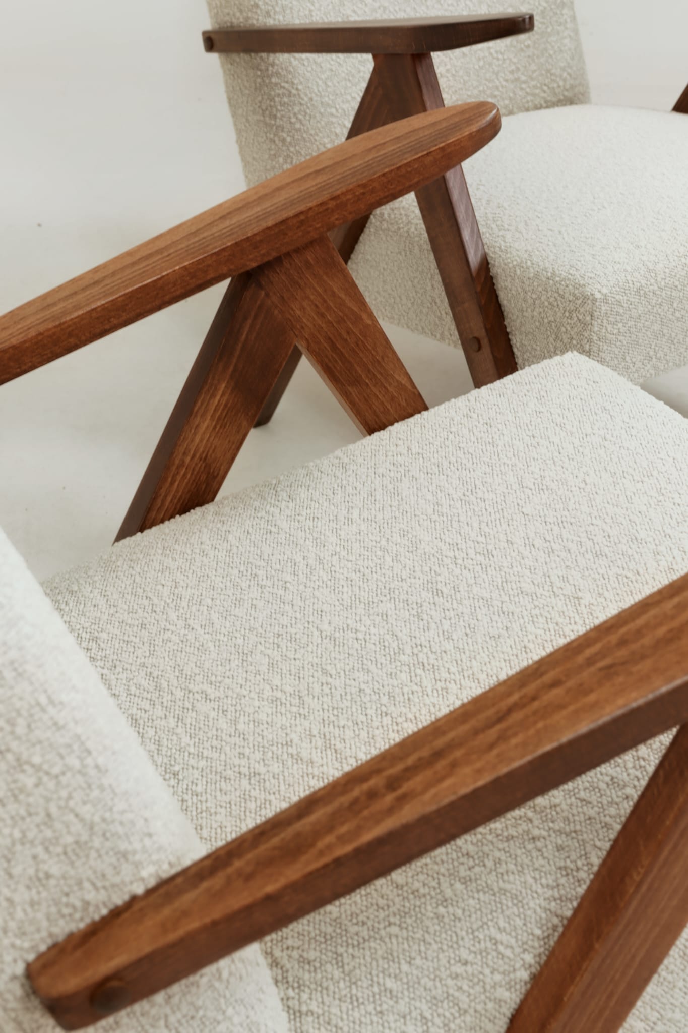 Pair of Mid-Century Modern armchairs in solid beech and boucle fabric.