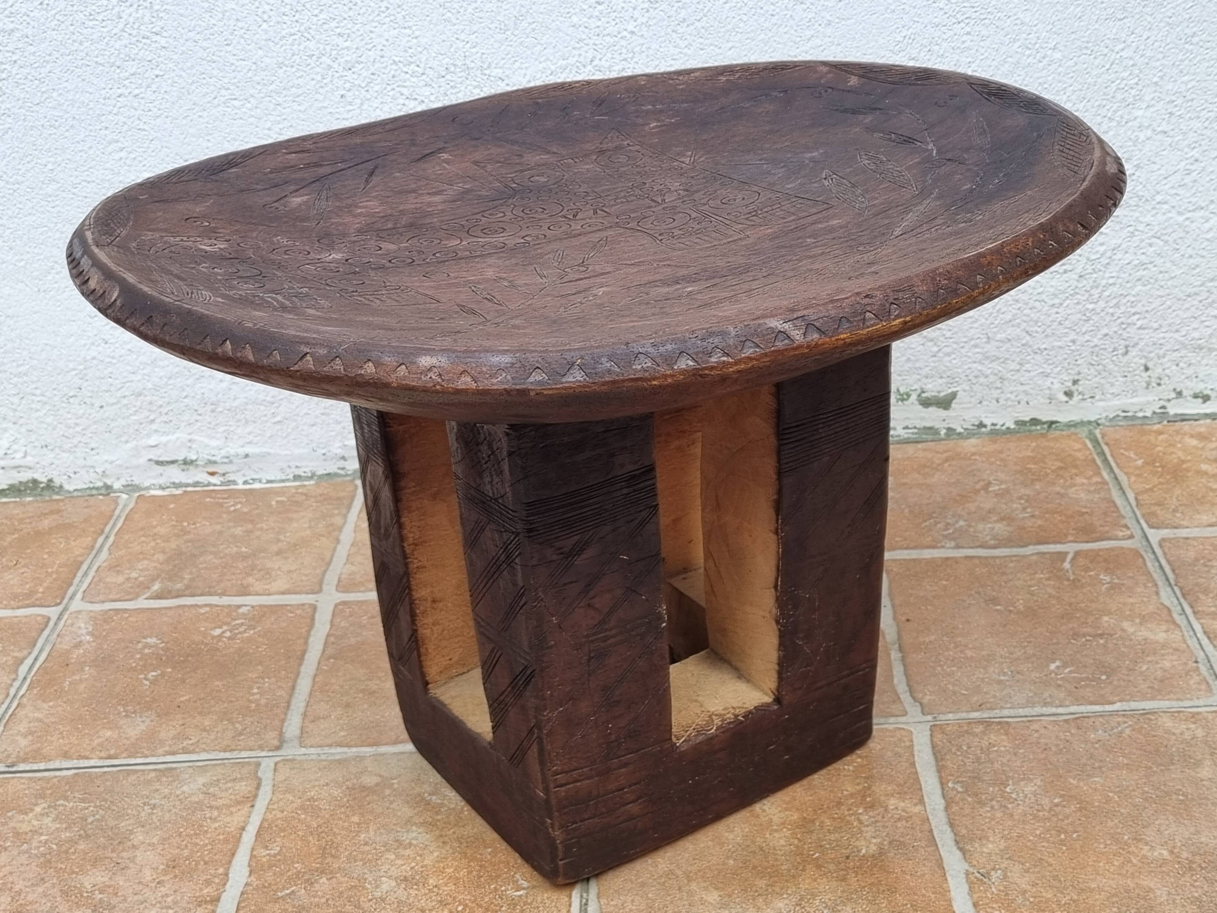 African monoxyle side table in carved wood with a curved top, 48x36 cm.