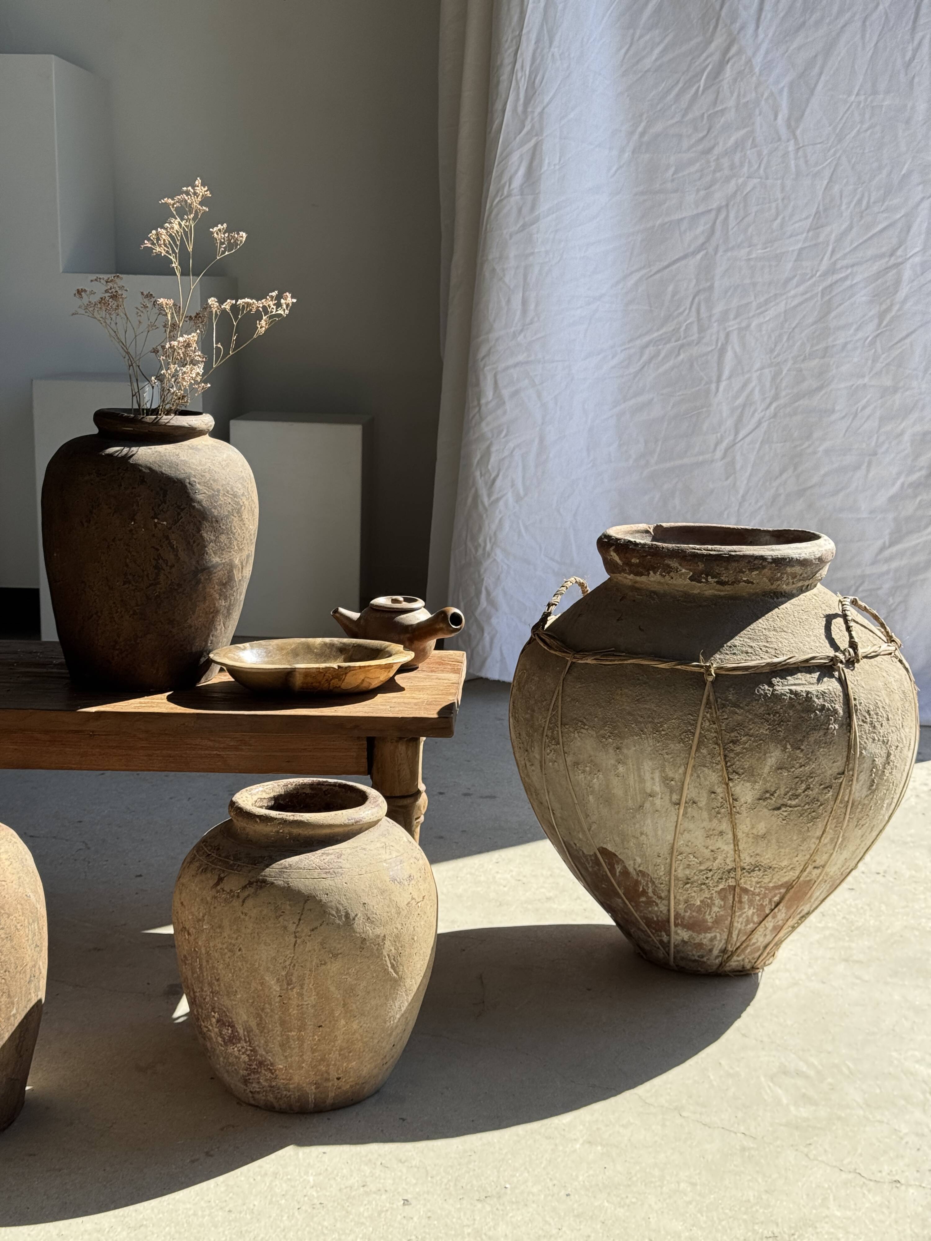 Very large grey and red terracotta pot with handles and rattan crossbars.