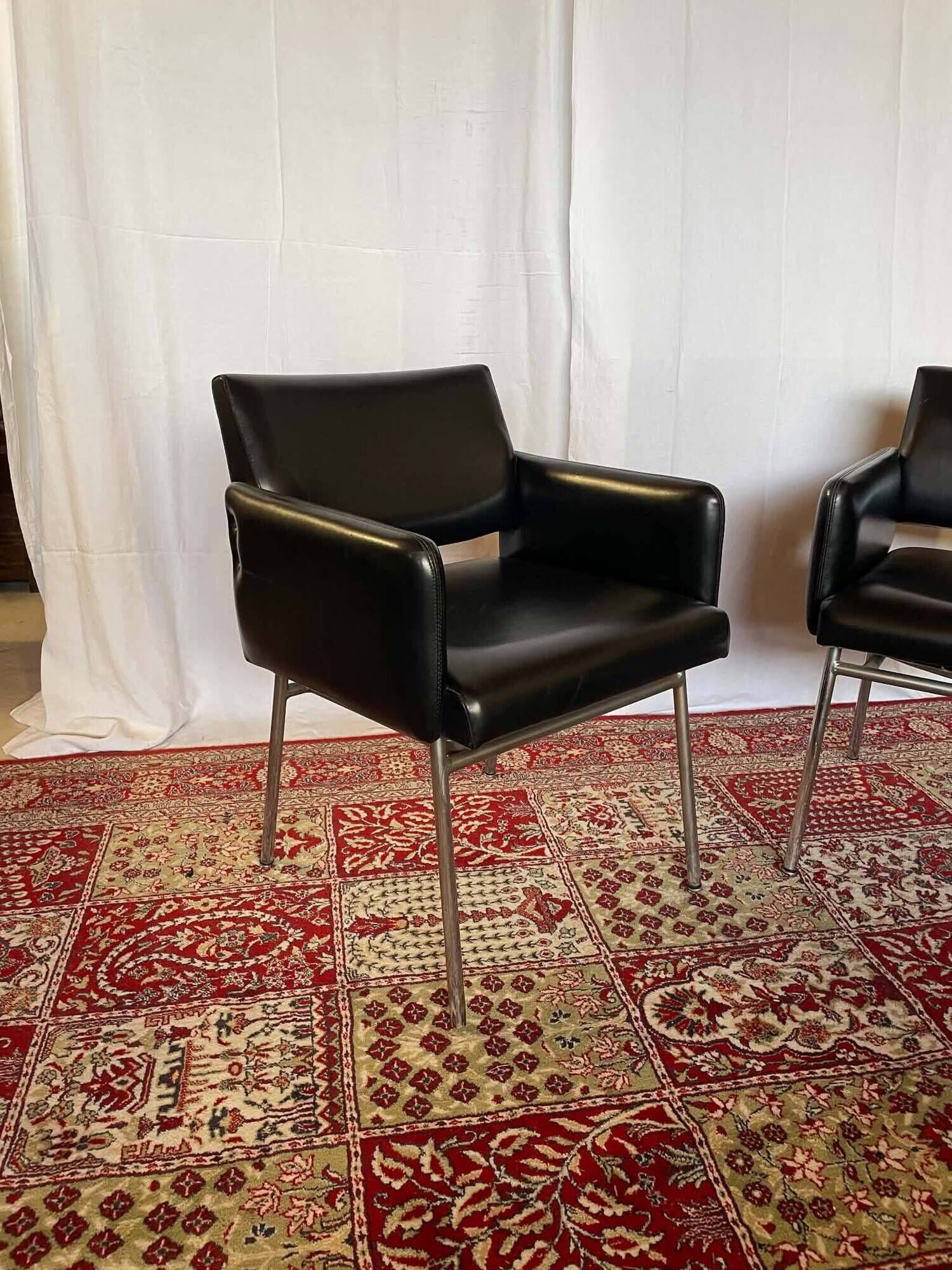 Pair of vintage armchairs in black faux leather and chrome metal.