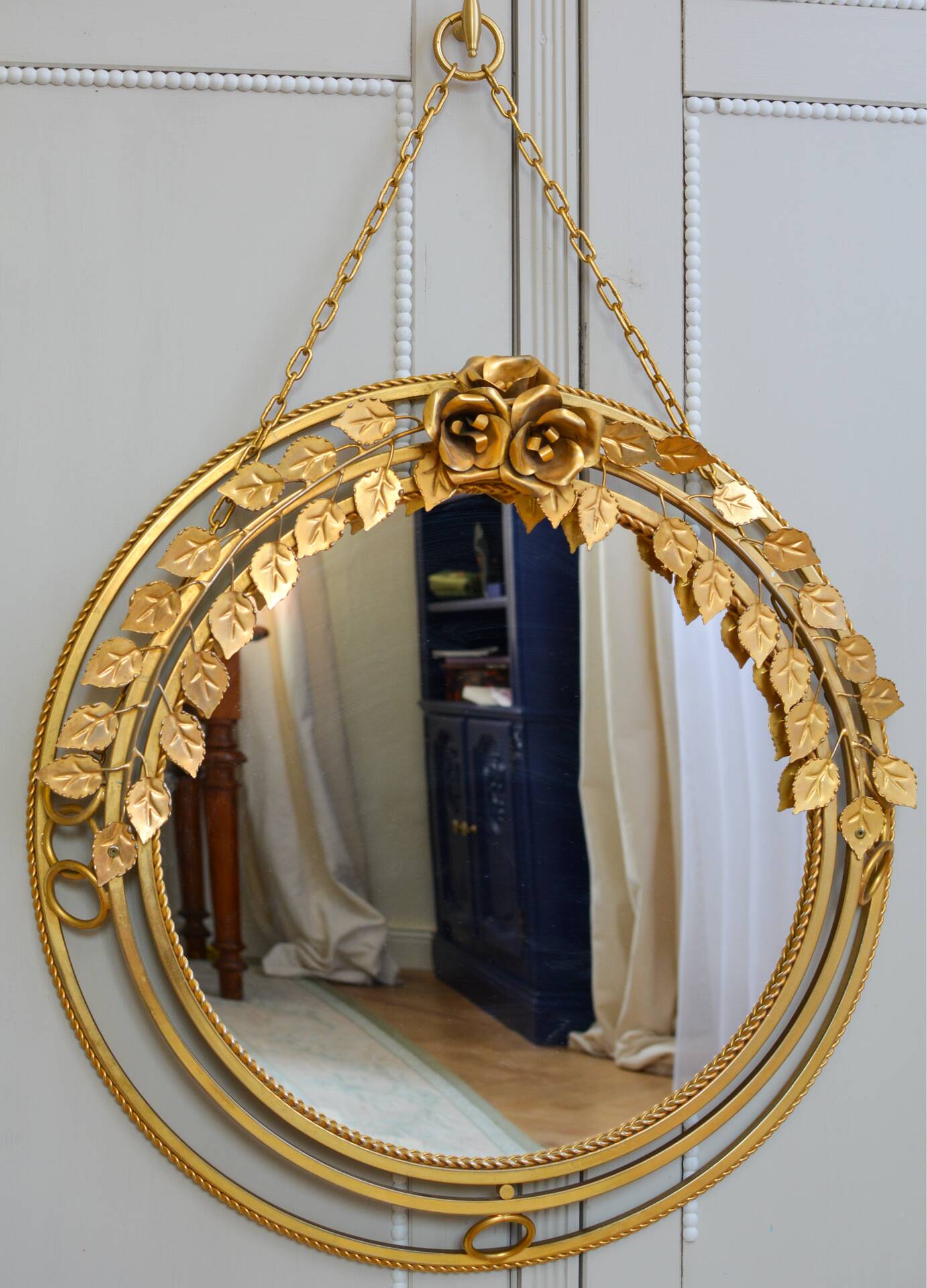 Vintage round illuminated mirror in gold metal with rose decoration.