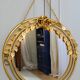 Vintage round illuminated mirror in gold metal with rose decoration.