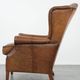 Fauteuil à oreilles de style anglais couleur cognac en cuir de vache.
