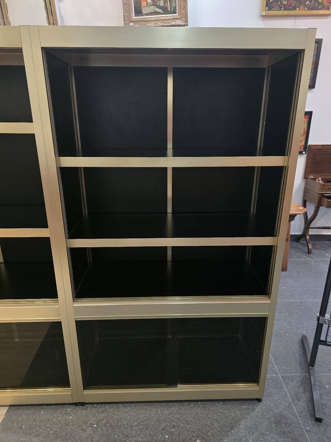 1970s design library with gold metal and lacquered wood.