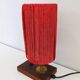 Small lamp made of wood, brass, and wool.