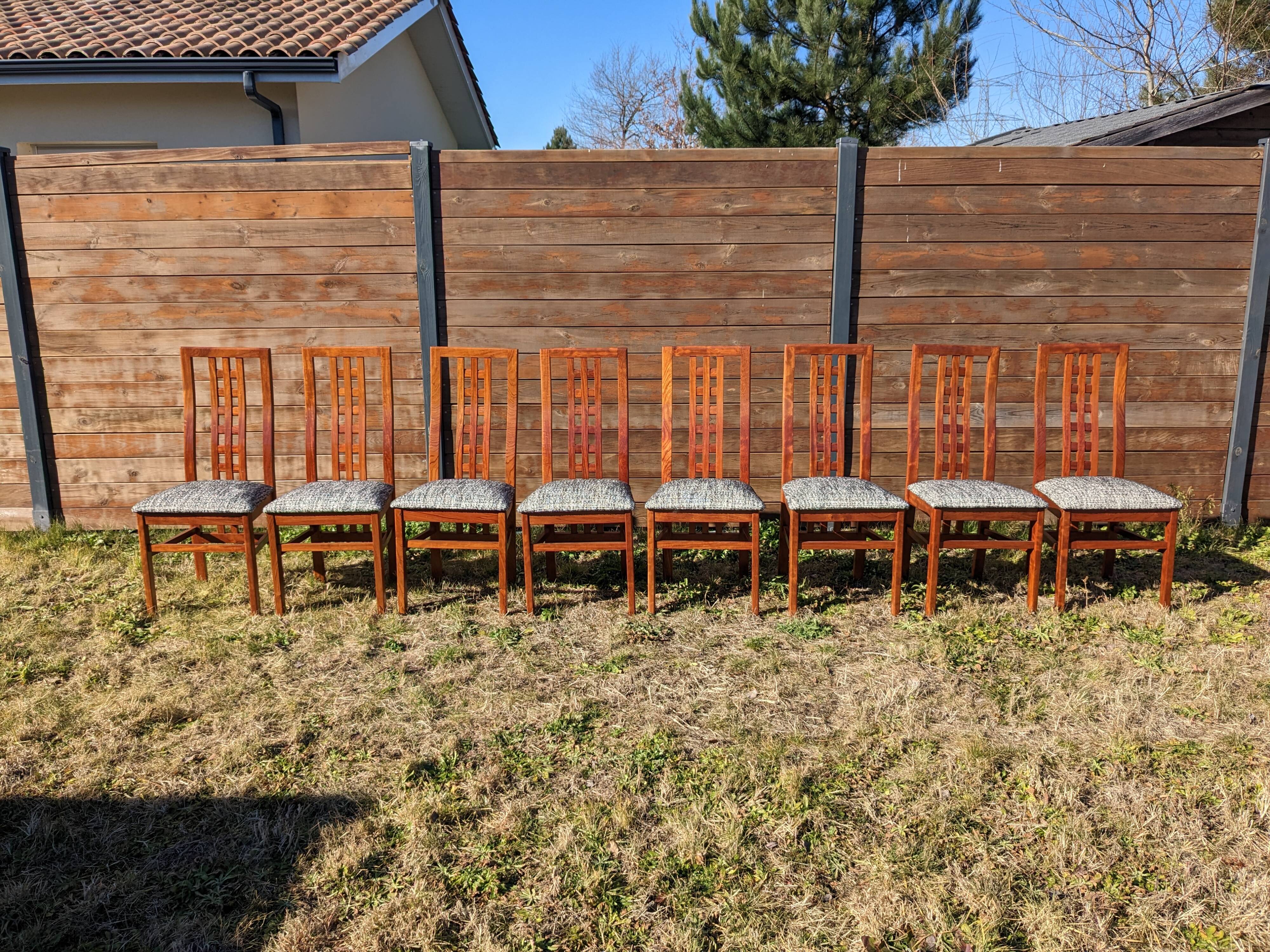 Set of 8 teak lounge chairs with high backs and zebra-striped seats