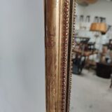 Long wooden mirror and gilded stucco with pearl rays H: 2m45 L: 40cm