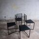 Set of 4 minimalist black steel dining chairs.