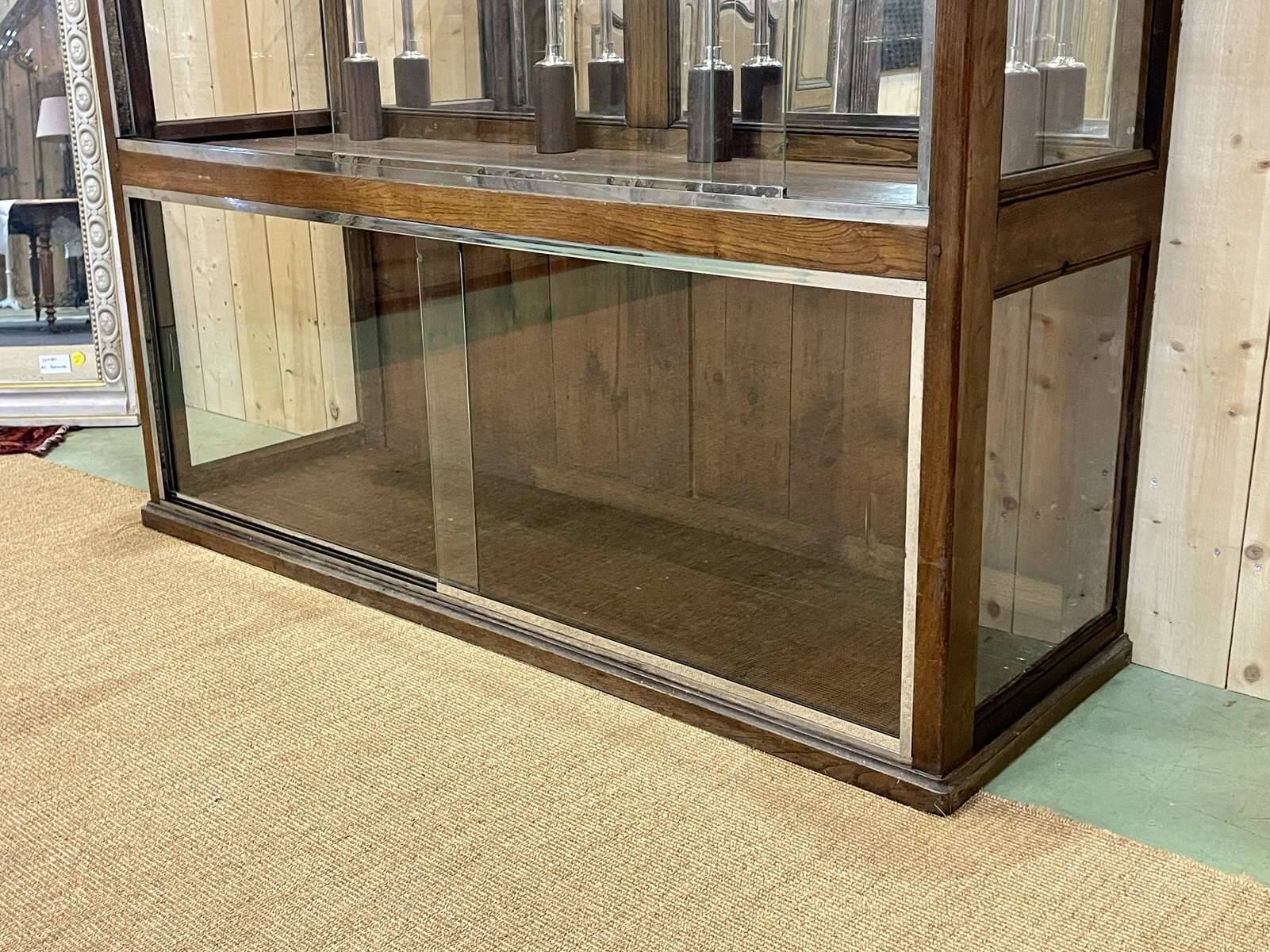 Early 20th-century shop display cabinet in oak with sliding doors.