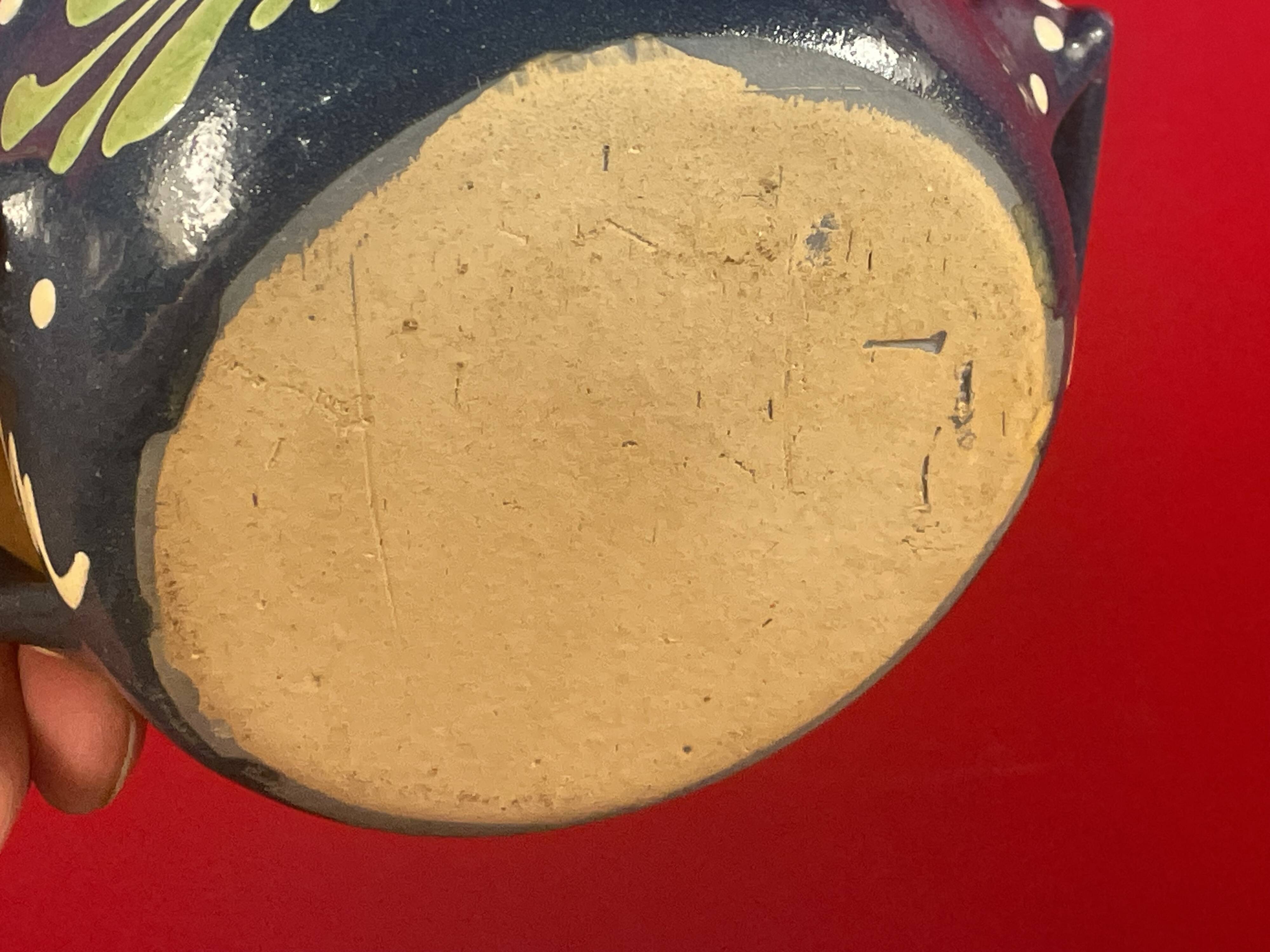 Small covered terracotta pot enamelled savoie or alsace flowers on a blue background