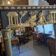 Large Empire-style mirror in dark green painted wood and gilded stucco.