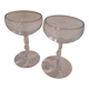 Two small crystal champagne glasses with twisted stems.