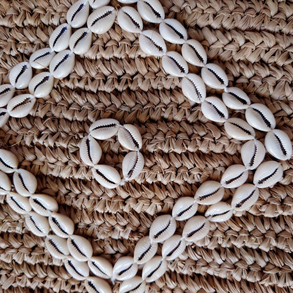 Cushion cover in natural raffia, shells and embroidery in macramé.