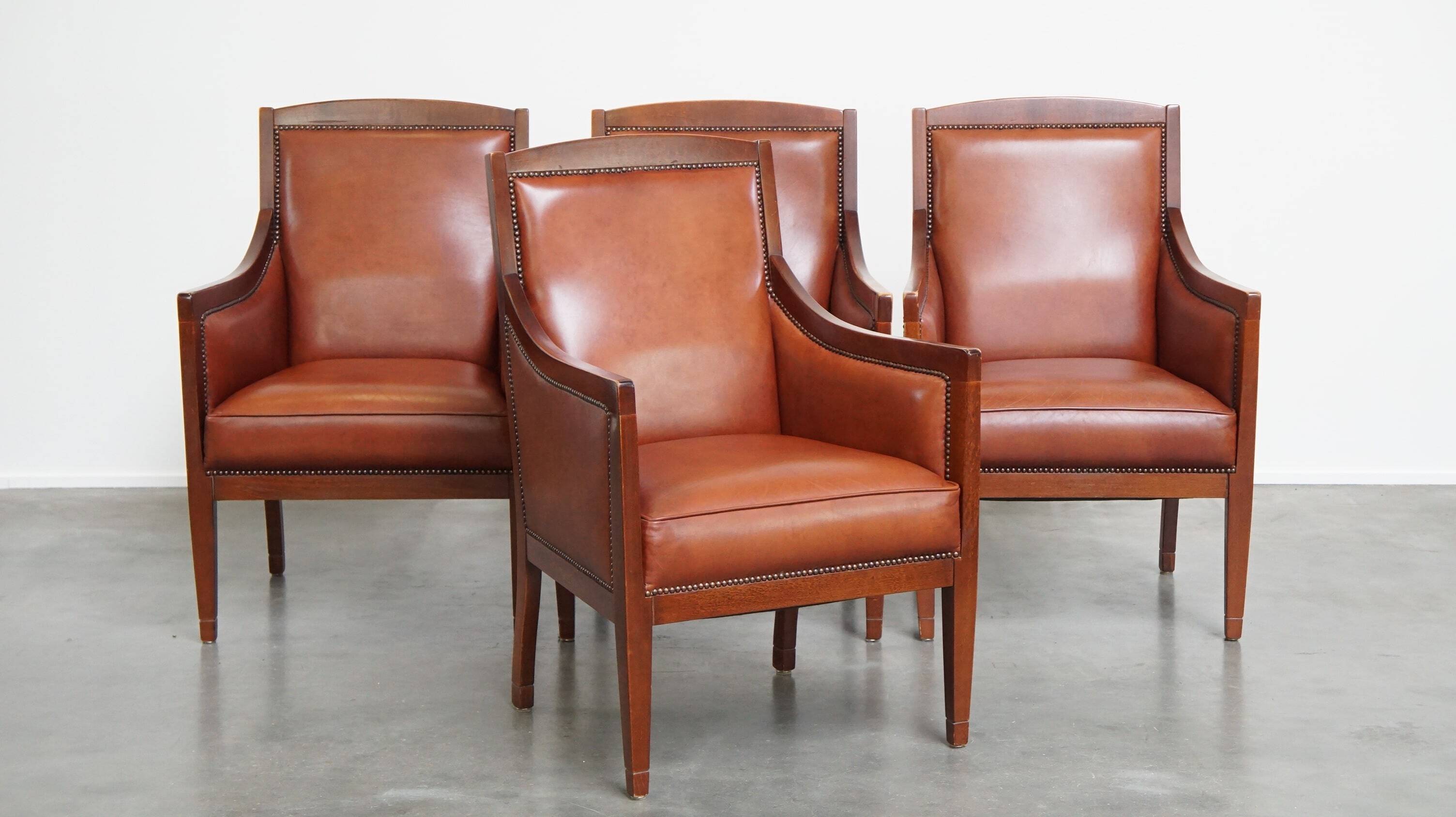 Ensemble majestueux et luxueux de 4 fauteuils design Art Déco en cuir de vachette couleur cognac