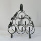 Vintage black wrought iron bottle holder decorated with vine leaves