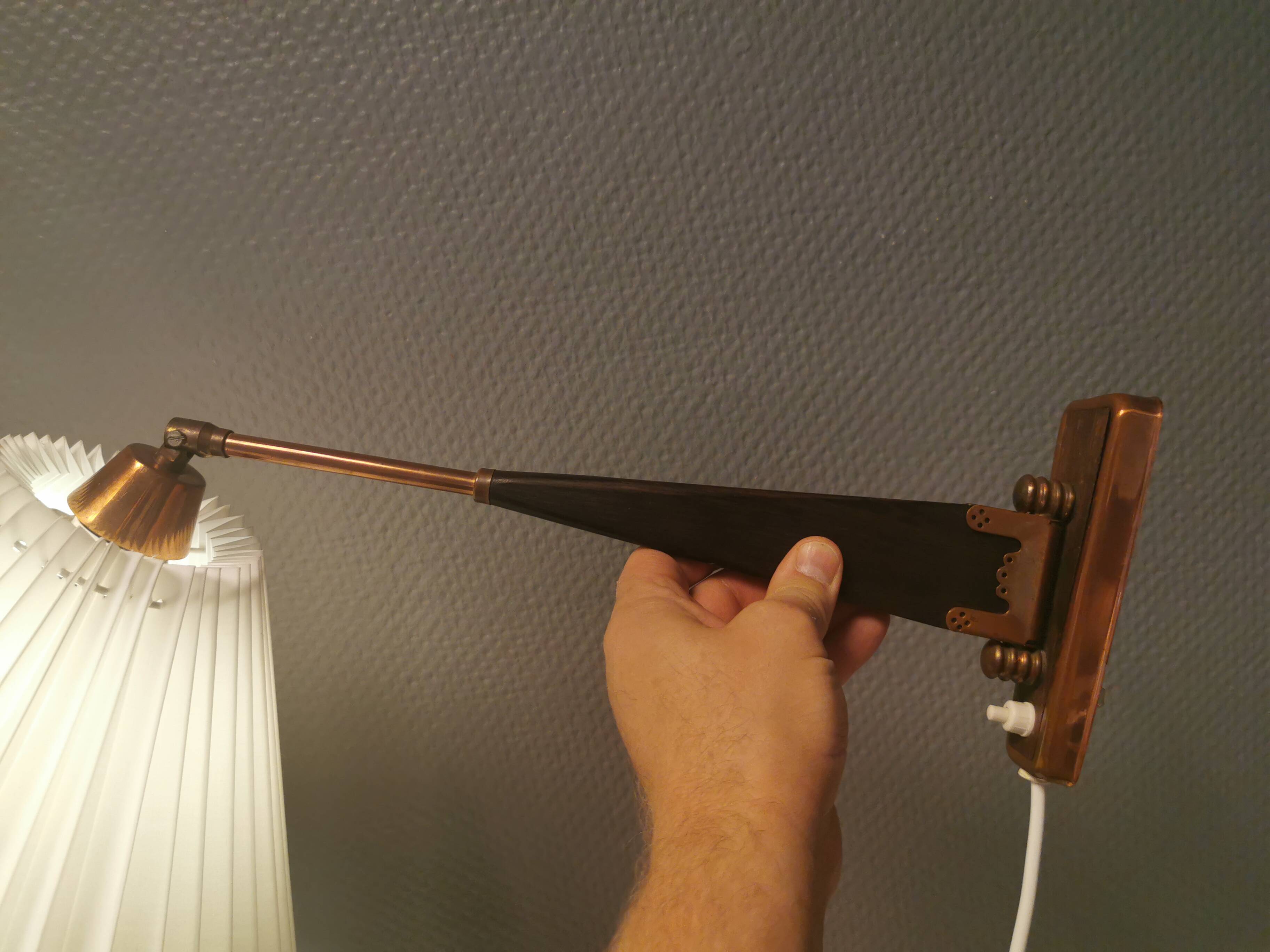 Wall lamp with adjustable ‘arm’ in copper and rosewood, with white shade.