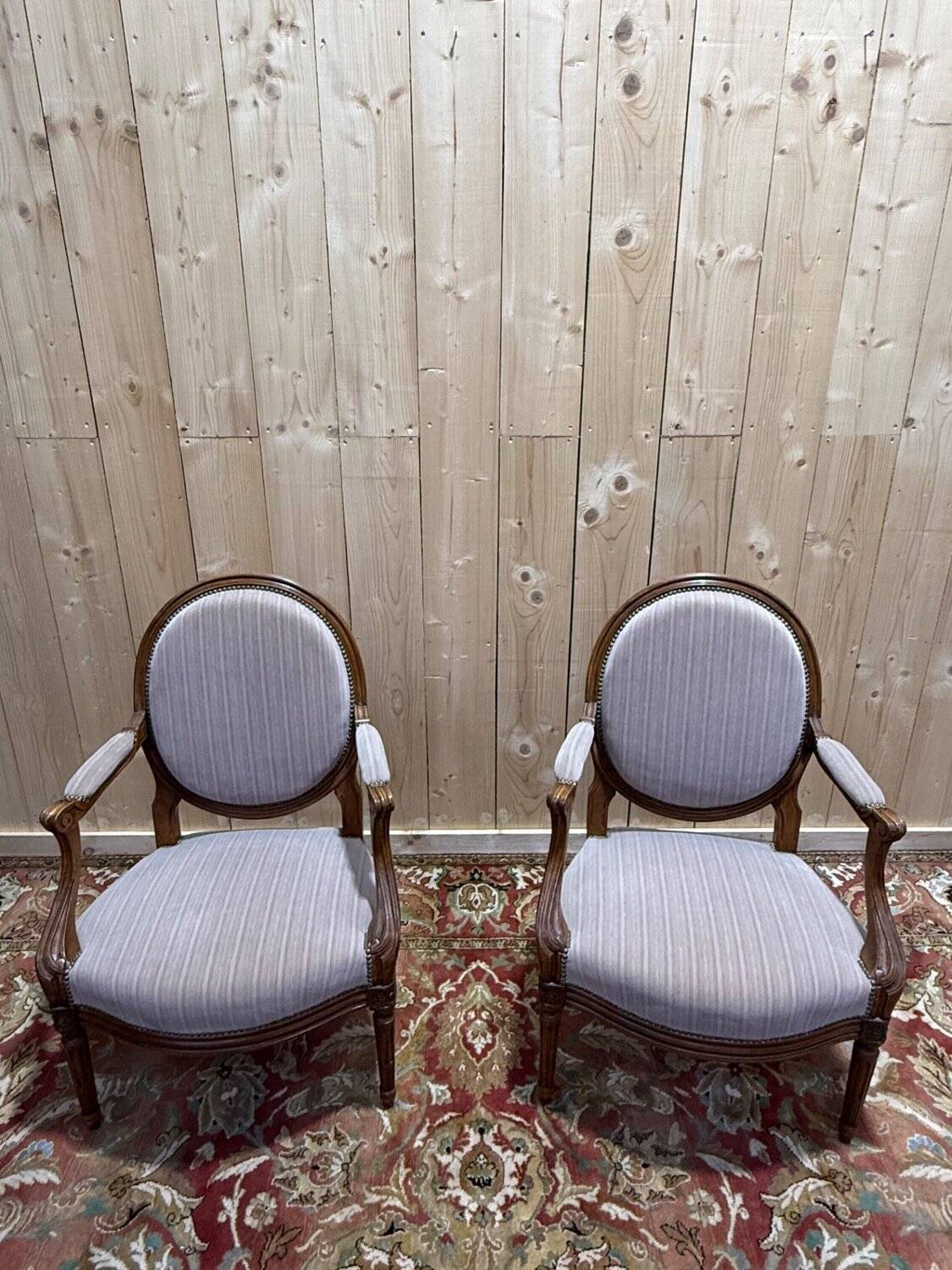 Pair of Louis XVI cabriolet armchairs with medallion backrest.