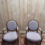 Pair of Louis XVI cabriolet armchairs with medallion backrest.