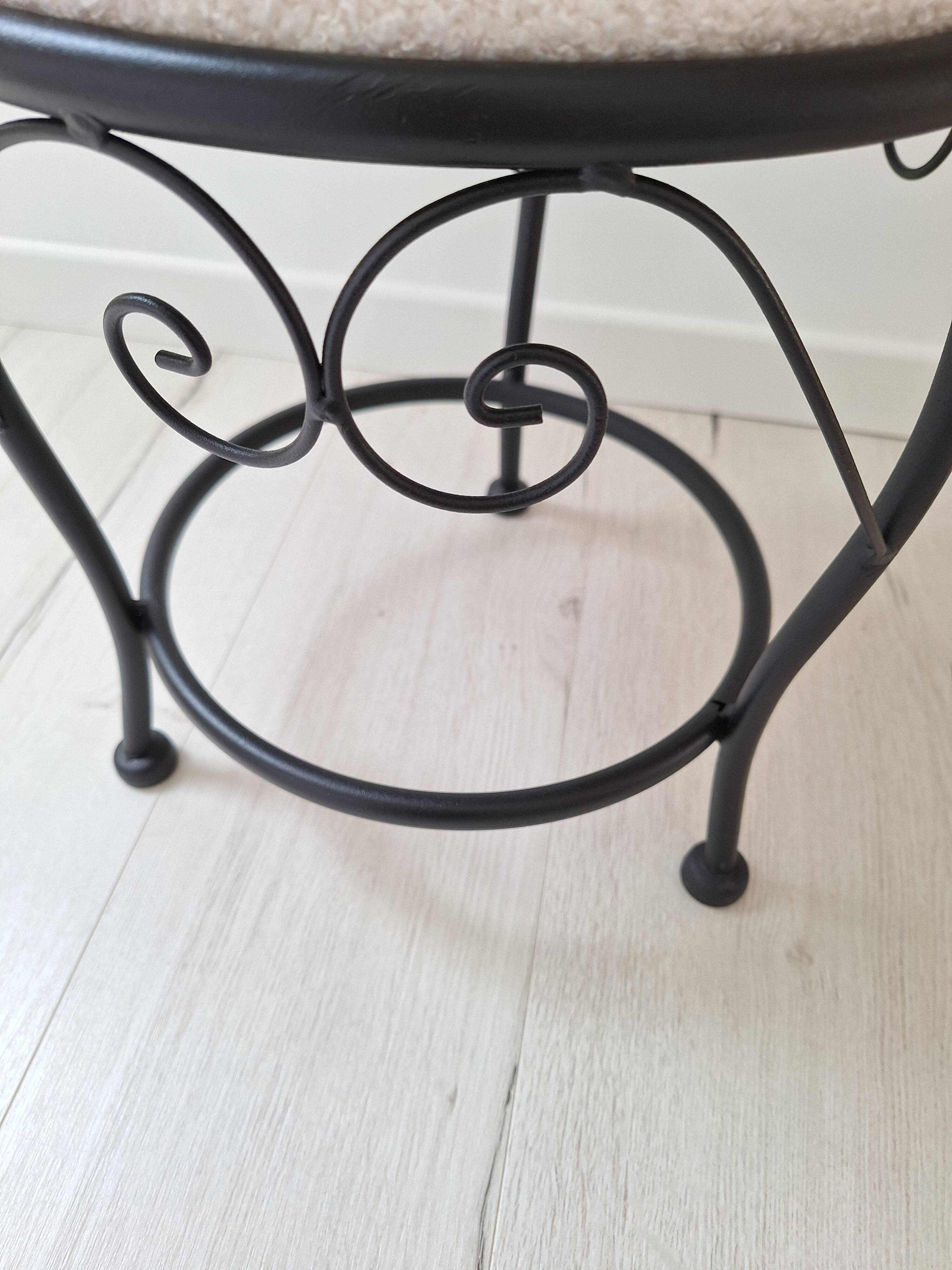 Black iron stool/pouf with its boucle fabric cushion.